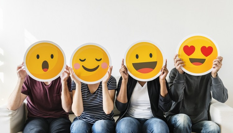 Diverse people holding emoticon